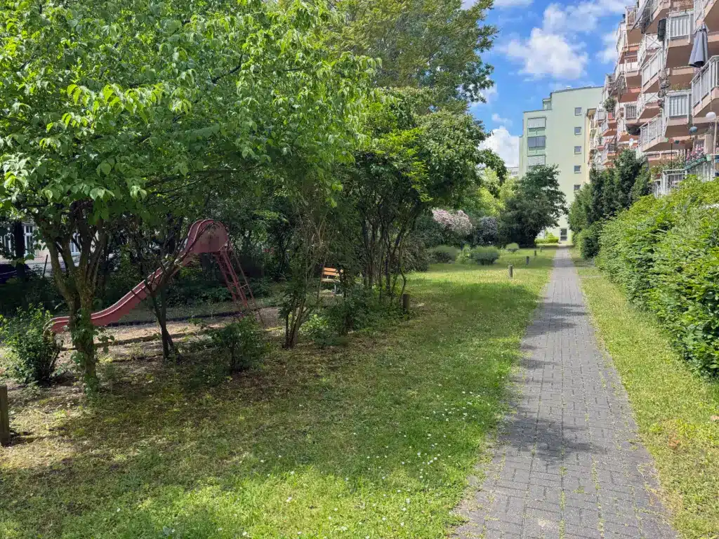 Schöner Garten der Tagespflege Palisadenstraße in Berlin-Friedrichshain mit verschlungener Wegeführung und Sitzbank