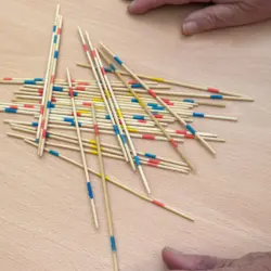 Mehrere Senioren spielen Mikado mit einer Betreuungsassistentin – Feinmotorik fördern in der Tagespflege Berlin