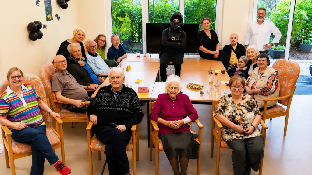 Gruppenfoto mit Internetstar Bermo_fit als Batman und den Gästen der anbosa Homecare Tagespflege in Berlin-Friedrichshain.